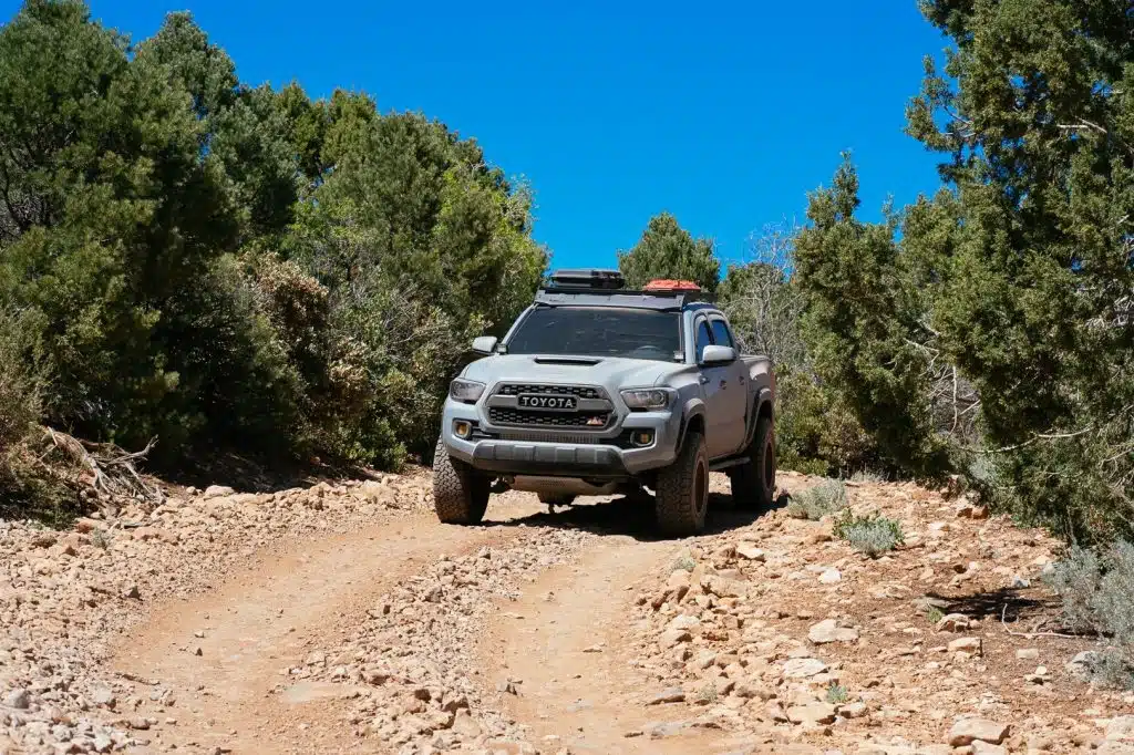Toyota Tacoma driving down dirt road