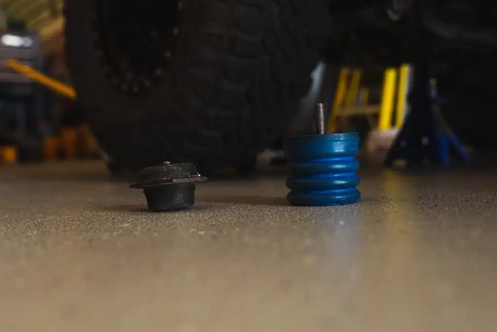 Blue SumoSprings compared to factory bump stop for front of Toyota Tacoma