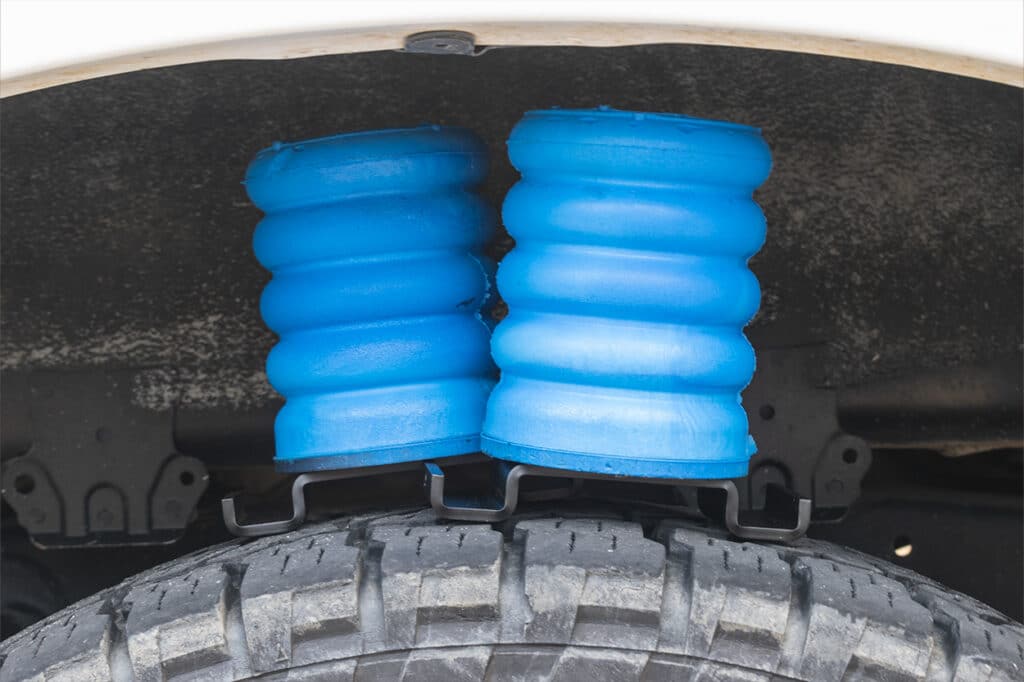 Blue SumoSprings sitting in wheel well of Toyota Tundra