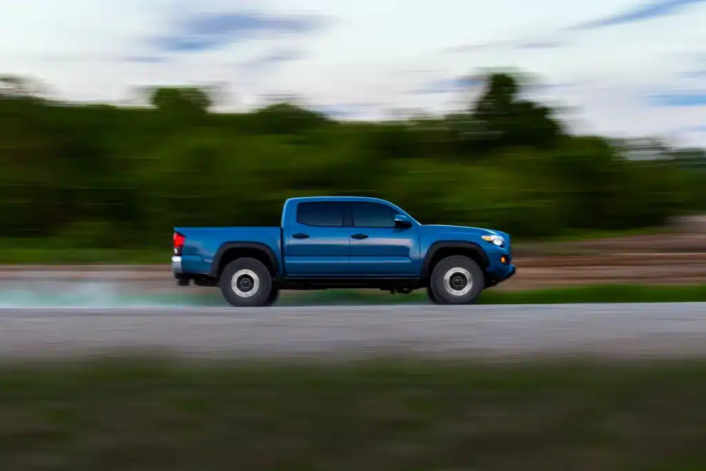 Blue Toyota Tacoma driving down the road
